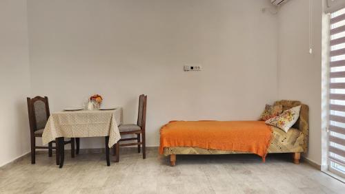 Zimmer mit einem Tisch, einem Bett, einem Tisch und einem Stuhl in der Unterkunft Maria in Igalo