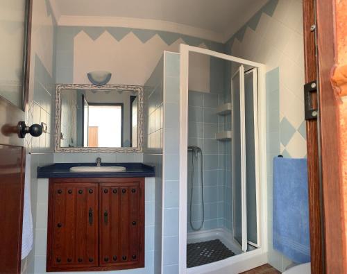 a bathroom with a sink and a shower with a mirror at Casa de María in Valle de Abdalagís
