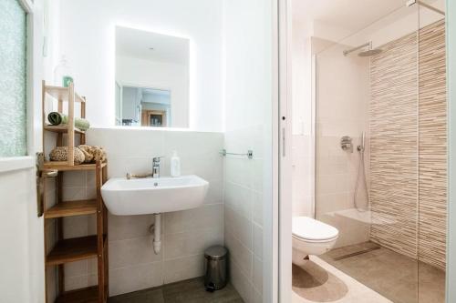 een witte badkamer met een wastafel en een toilet bij Lemon Tree Lake View - by MyHomeInComo in Laglio