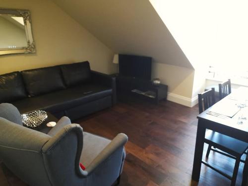 Kirkcudbright Holiday Apartments - Apartment G في كيركودبرايت: غرفة معيشة مع أريكة وطاولة