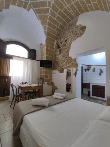 a bedroom with a large bed and a dining room at B&B Punta Cutieri in Gallipoli