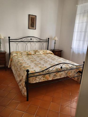 a bedroom with a bed with a floral comforter at Marina's house in Imperia