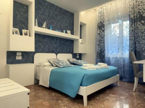 a bedroom with a bed with a blue comforter at ComfortHouse LaVilla in Ladispoli