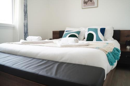 a large bed with white sheets and pillows on it at Villa Fontenailles in Mâcon