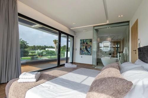 a bedroom with a large bed and a large window at Armonia Luxury Villa in Ialysos