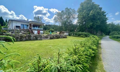 a house with a stone wall next to a road at Lipno Villa Beach - Lipno Stausee - Lakeside in Loučovice