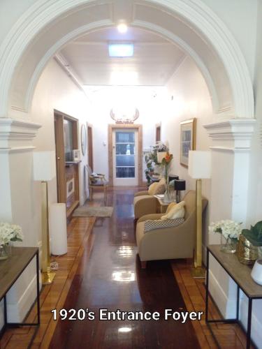 a living room with a couch and chairs in a room at Fawkner Mansions Heritage Hotel in Melbourne