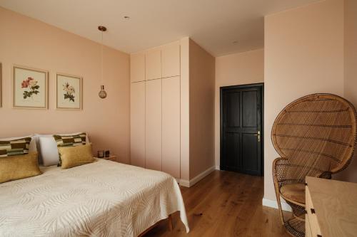 a bedroom with a bed and a wicker chair at Lighthouse View Apartment in Żebbuġ