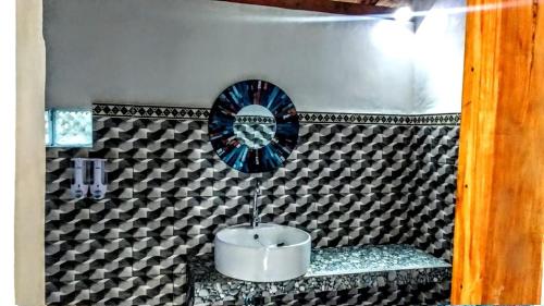 a bathroom with a sink and a plate on a wall at Vina Bungalow in Toyapakeh