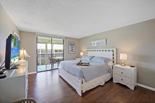 - une chambre avec un lit, une télévision et un balcon dans l'établissement Island Club II 10, à Marco Island