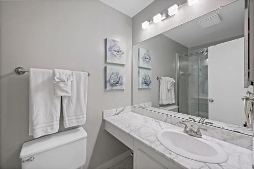La salle de bains blanche est pourvue d'un lavabo et d'un miroir. dans l'établissement Island Club II 10, à Marco Island