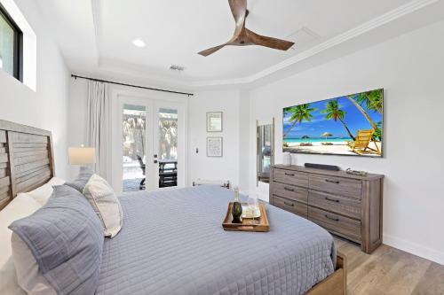 ein weißes Schlafzimmer mit einem Bett und einer Kommode in der Unterkunft 270 West Flamingo Circle in Marco Island