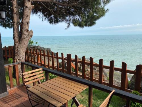 a wooden bench sitting next to a fence near the ocean at Vira Otel Suites in Sinop