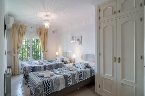 1 dormitorio con 2 camas y ventana grande en Ballyraine, en Nerja