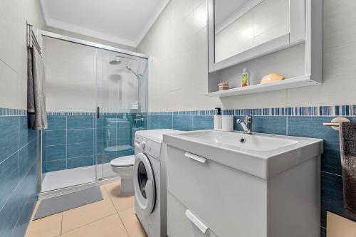 y baño con lavadora y lavamanos. en Home2Book Charming Apartment Tinajo, Wifi, en La Santa