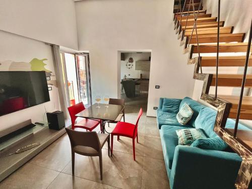 een woonkamer met een blauwe bank en een tafel en stoelen bij Casa Piazzetta Camilleri in Porto Empedocle