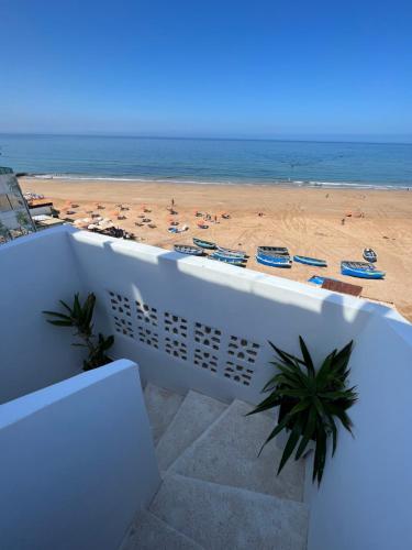 a view of the beach from the balcony of a building at Single fin beach house in Taghazout