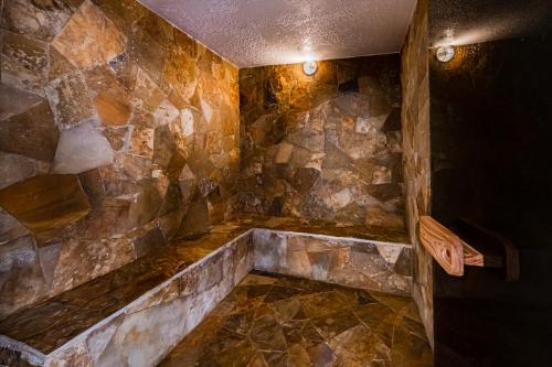 a bathroom with a stone wall and a tub at Dormio Resort Costa Blanca Beach & Spa in El Campello