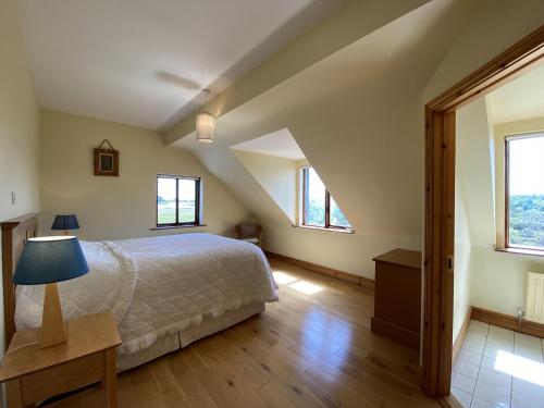 a bedroom with a bed and two windows at Property 450 - Oughterard in Oughterard