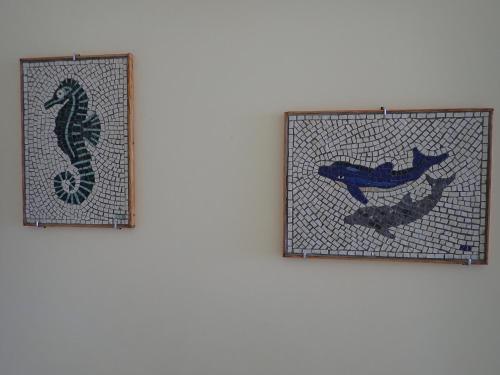 two stained glass pictures of a seahorse on a wall at Beachfront Residence With Private Path To The Sea in Poros