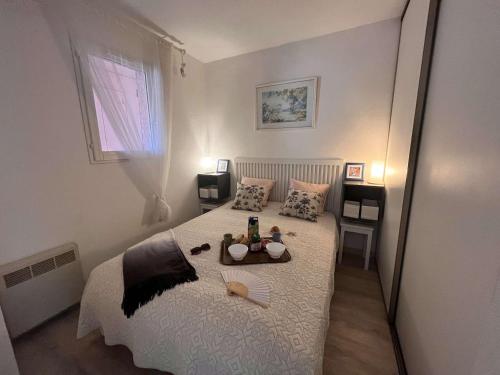 - une chambre avec un lit et un plateau de nourriture dans l'établissement Appartement 2 pièces avec terrasse et parking à 400m de la plage – Saint Aygulf - FR-1-226A-88, à Saint-Aygulf