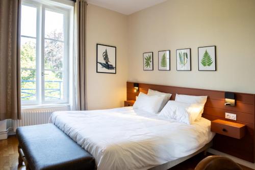 1 dormitorio con 1 cama blanca grande y ventana en Bel appartement, bien équipé et confortable dans le centre historique en Fougères