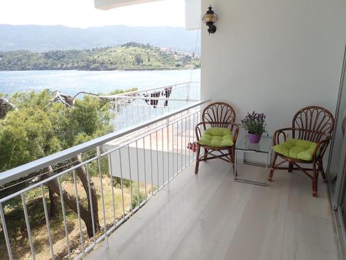 two chairs on a balcony with a view of the water at Beachfront Residence With Private Path To The Sea in Poros