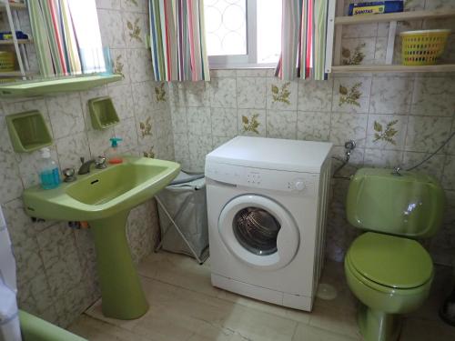 a bathroom with a washing machine and a green sink at Beachfront Residence With Private Path To The Sea in Poros