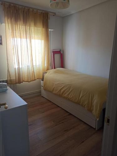 um pequeno quarto com uma cama e uma janela em Apartamento en Plentzia en barrio muy tranquilo con aparcamiento gratuito y al lado del metro em Elejalde