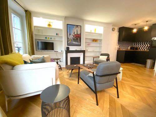 un salon avec un canapé et une cheminée dans l'établissement L'appartement Letac, à Paris