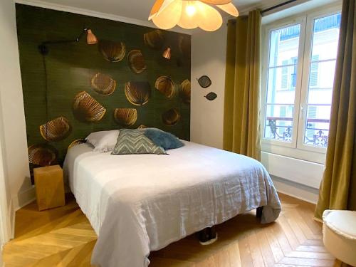 - une chambre avec un lit recouvert de coquillages dans l'établissement L'appartement Letac, à Paris