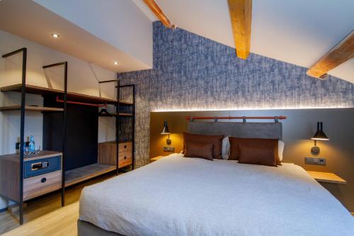ein Schlafzimmer mit einem großen Bett und einem TV in der Unterkunft DAS Hotel by Hopfenschlingel in Rastatt