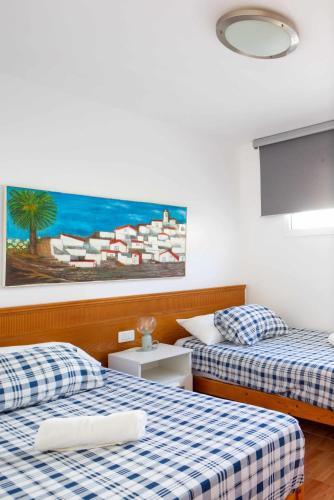 a room with two beds and a painting on the wall at Apartamento Maypa 1 Calma in San Bartolomé