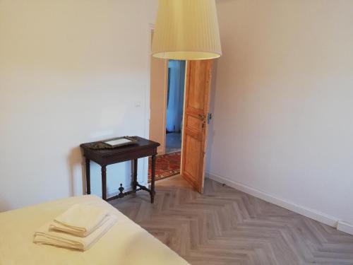 a room with a bed and a table and a lamp at Les 3 Platanes in Conilhac-Corbières