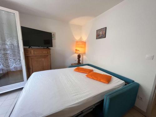 - une chambre avec un lit doté d'un oreiller orange dans l'établissement Appartement 2 pièces avec terrasse, piscine, parking privé et proche plage à Saint-Aygulf - FR-1-226A-87, à Saint-Aygulf