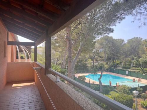 - une vue sur la piscine depuis le balcon d'une maison dans l'établissement Appartement 2 pièces avec terrasse, piscine, parking privé et proche plage à Saint-Aygulf - FR-1-226A-87, à Saint-Aygulf