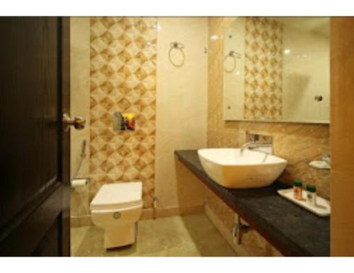 a bathroom with a sink and a toilet at Shiva Farm, Hotel Baramasa By Welinna Group, Dehradun in Dehradun