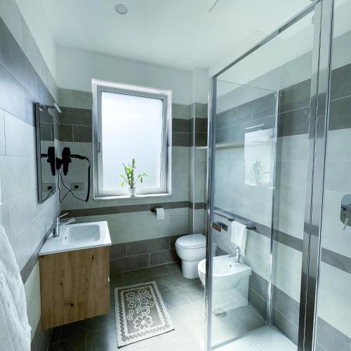 a bathroom with a toilet and a sink and a shower at Resort Policastro in Policastro Bussentino