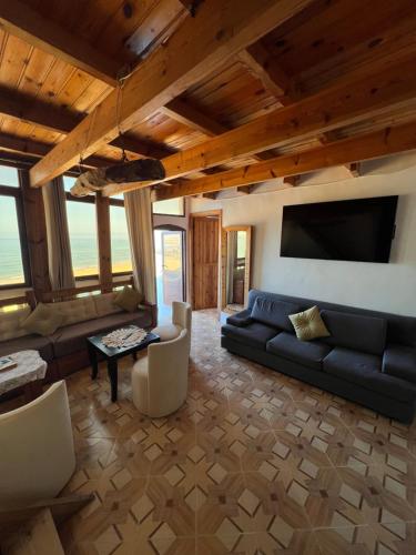 ein Wohnzimmer mit einem Sofa und einem TV in der Unterkunft Single fin beach house in Taghazout