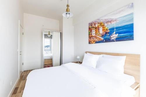 a bedroom with a white bed and a painting on the wall at Sea View New Built Residence Near Kartal Coast in Istanbul