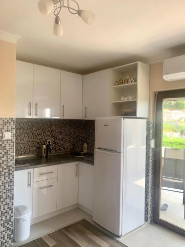 a kitchen with white cabinets and a white refrigerator at Apartments Neira near Dubrovnik in Ivanica