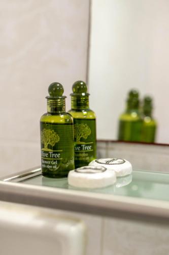 three green bottles sitting on a counter top at Armonia Hotel by Zante Plaza in Laganas
