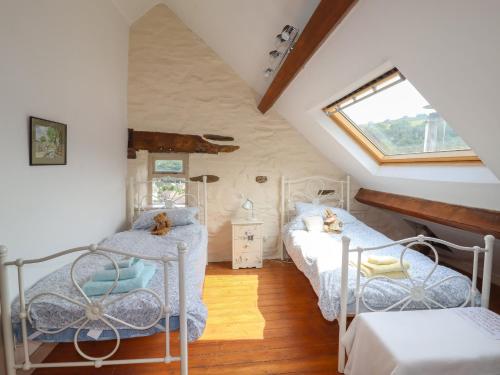 a attic room with two beds and a window at Chapel House in Llangollen