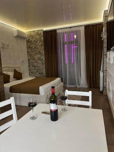 a bottle of wine sitting on a table with two glasses at Moonlight Apart-Hotel Batumi in Batumi