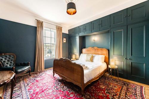 een slaapkamer met een bed, een bank en een stoel bij Wellington House - Norfolk Holiday Properties in Lowestoft