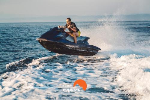 a man riding a jet ski in the water at #056 Old Post Office by Home Holidays in Albufeira
