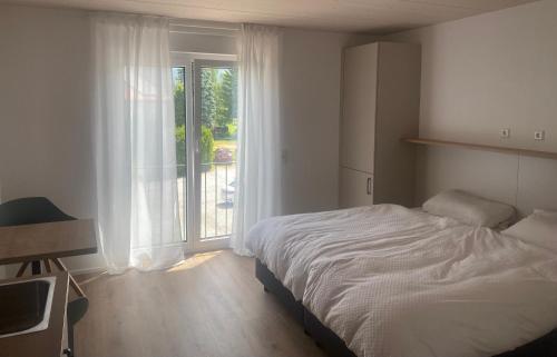 een slaapkamer met een bed en een groot raam bij Obstbau Apartment am See in Lindau