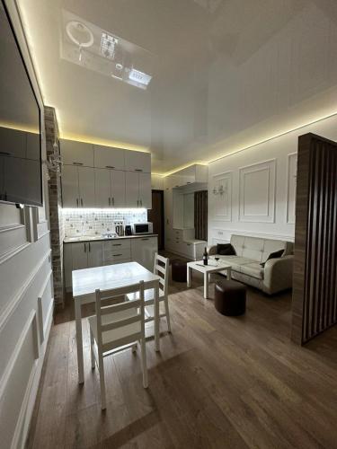 a kitchen and living room with a table and a couch at Moonlight Apart-Hotel Batumi in Batumi
