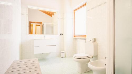 een witte badkamer met een toilet en een wastafel bij Lugana e Papaveri - Italian Homing in San Martino della Battaglia