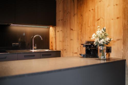 eine Küche mit einer Theke mit einer Blumenvase darauf in der Unterkunft Adlhof Apartments in Bruneck